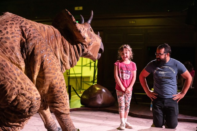 Girl on stage with Dakota the puppet during a Dinosaur Encounters show