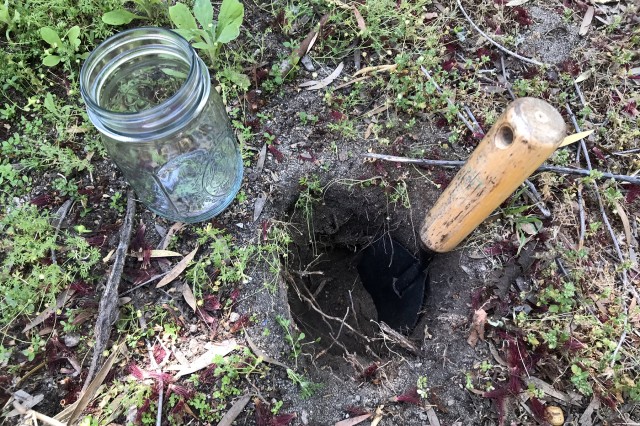 Cava un agujero en la tierra de una profundidad igual a la altura de tu contenedor.