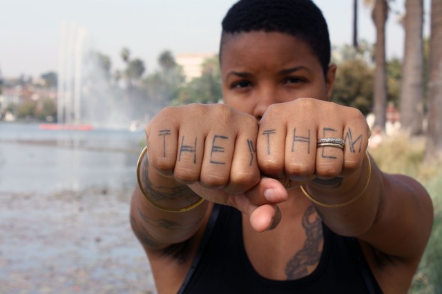 Madin Lopez with hands extended showing &quot;they&quot; and &quot;them&quot; pronouns 