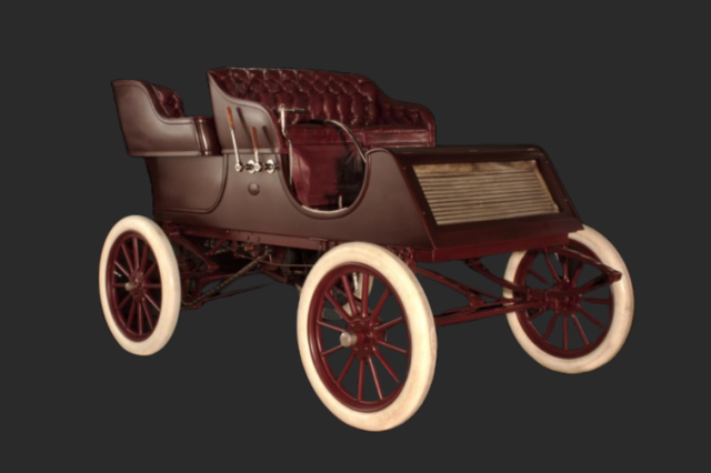 1902 wooden-body gasoline powered Tourist automobile with dark red leather interior and white rubber tires