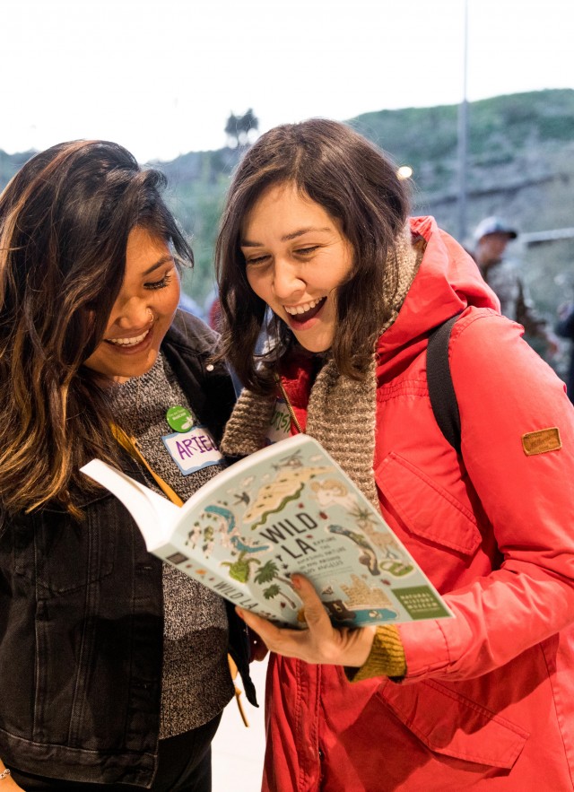 two women reading Wild LA book at community science super project party