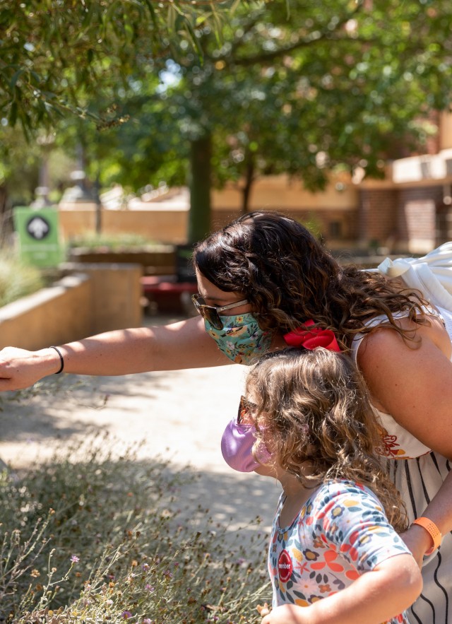 Member mother and daughter looking at bug hotel in nature gardens