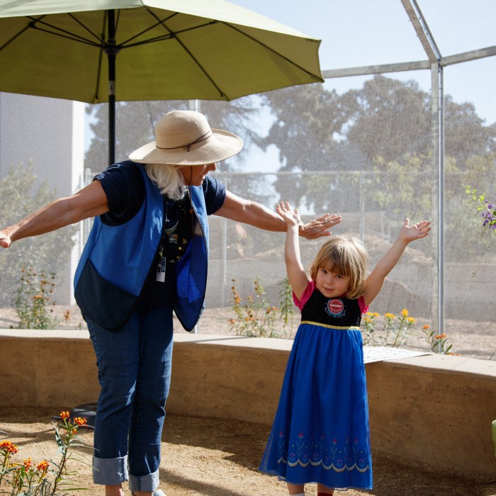 female volunteer with child in butterfly pavilion