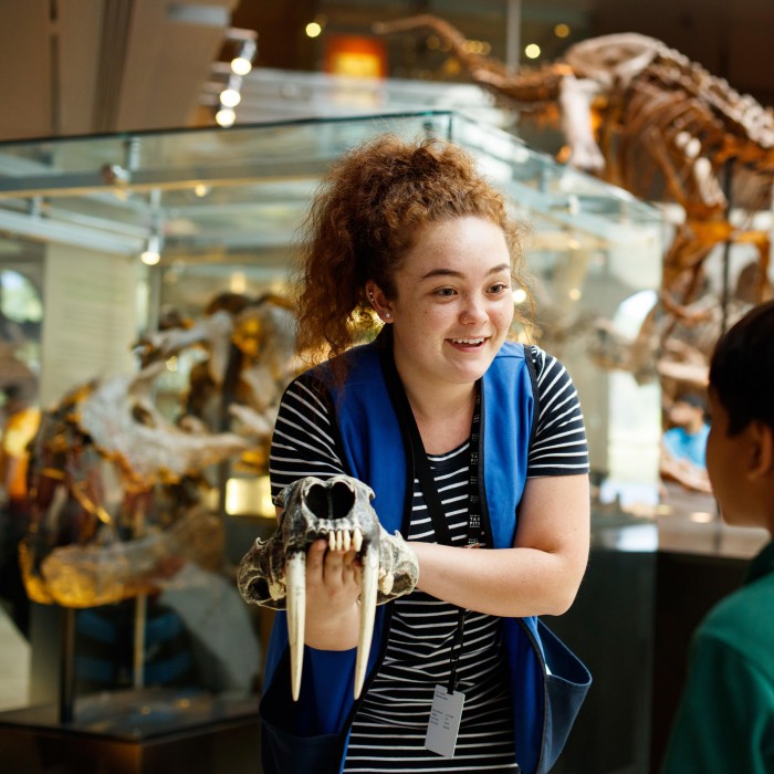 female volunteer with skull in dino hall