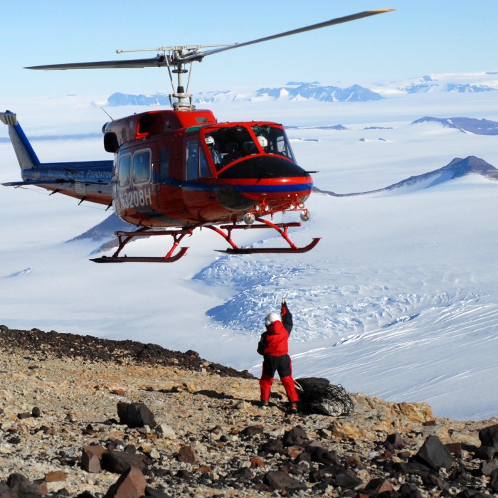 helicopter flying over person in antarctica