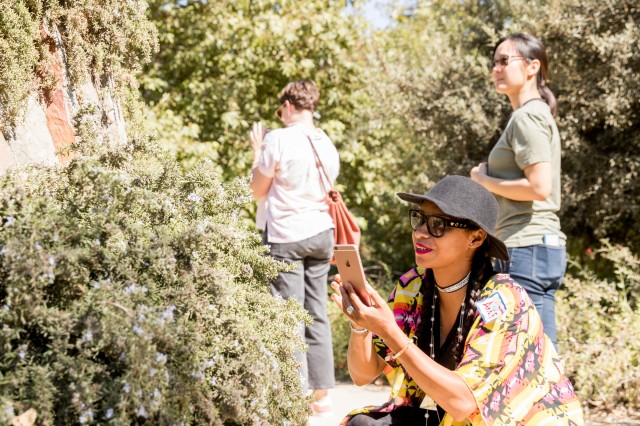 woman in nature gardens taking a picture superproject community science