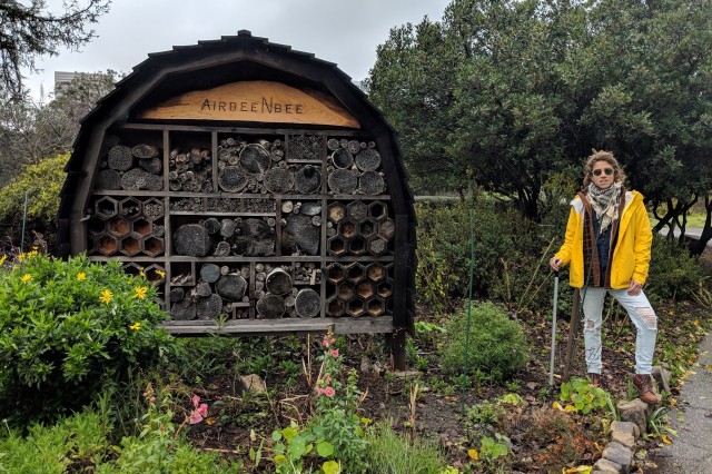 Kat Superfisky stands next to a bee hotel
