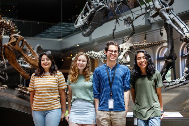 Dinosaur Institute interns standing in front of dinosaur skeletons in the Dinosaur Hall