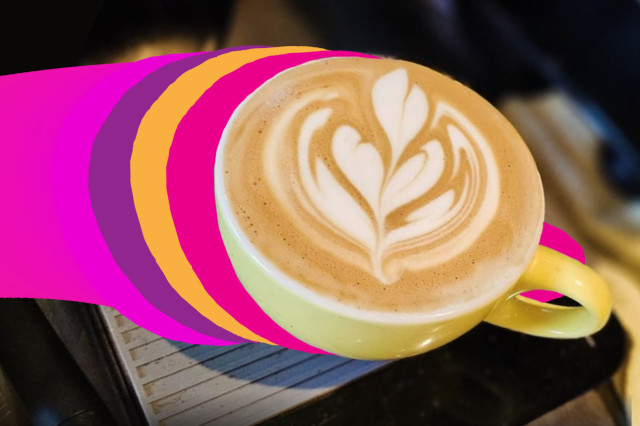 A top-down view of a latte in a yellow ceramic cup featuring heart-shaped foam art, set against a dark background with vibrant purple, pink, and orange graphic stripes flowing toward the cup.