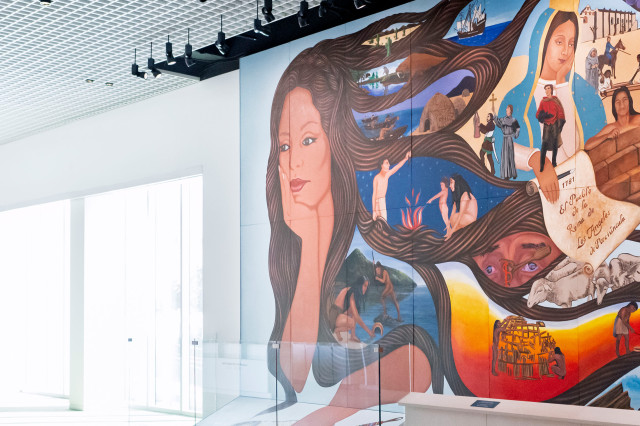 Mural of a woman with head in hand and vignettes within her hair