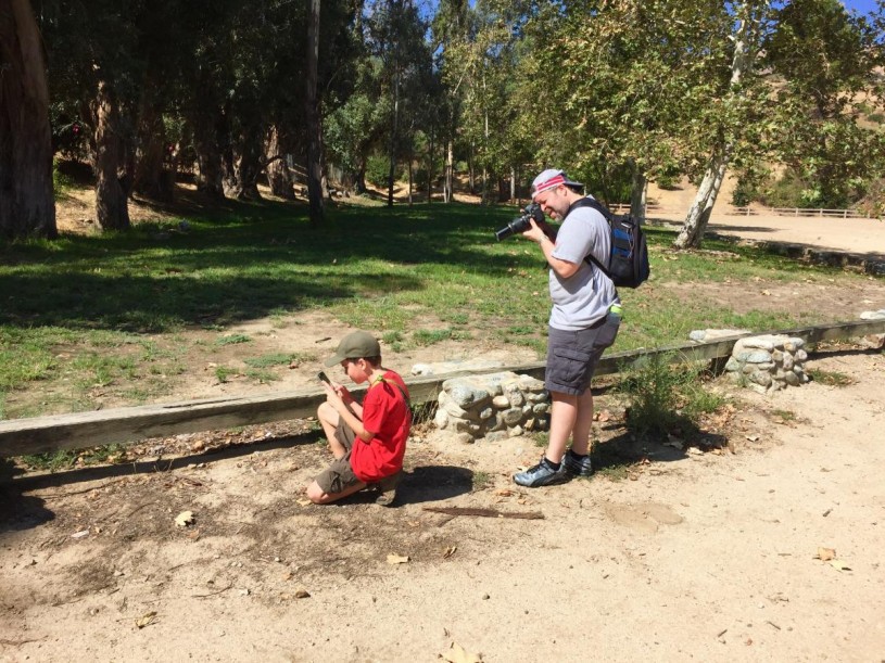 Father and son team John and Devin Larson photograph a lizard to submit to iNaturalist.