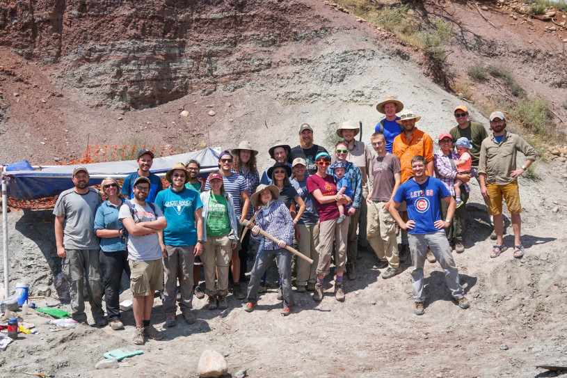 A group of people pose for a picture in the desert 