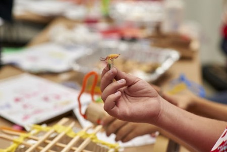 child's hand holding small toy they sifted from their simulated matrix